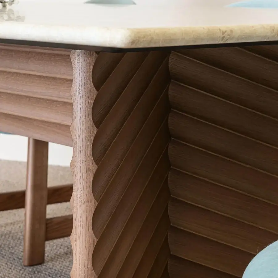 Elegant Moroso Rows table with a light stone top and dark brown MDF veneered oak base exhibiting horizontal ridges and a scalloped edge