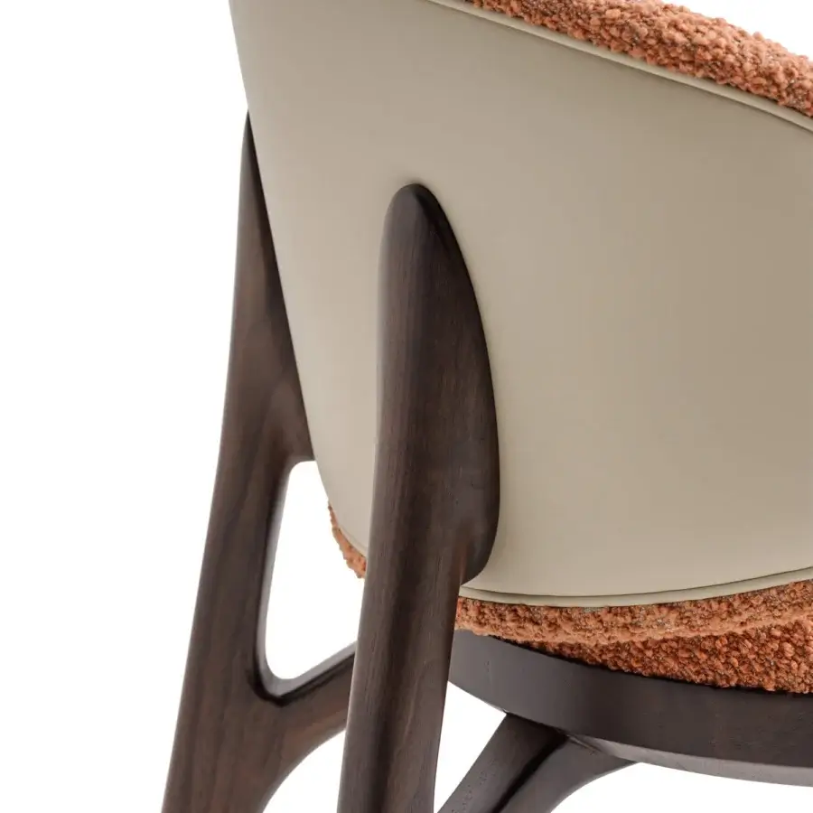 Distinguished Turri Pinnacle chair with orange-brown textured textile upholstery and curved light-colored backrest built with angular wooden legs