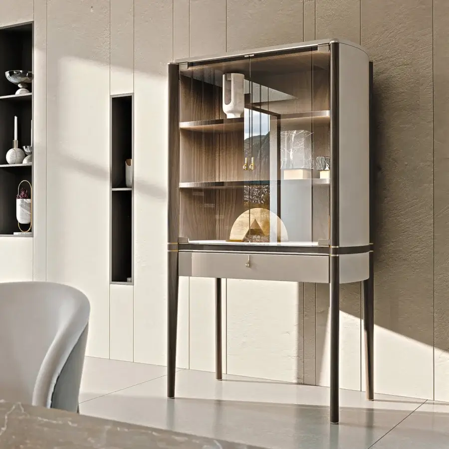 Distinguished Turri Pinnacle bar cabinet with curved sides and metal details in dark wood with wooden shelves and glass doors featuring internal lighting