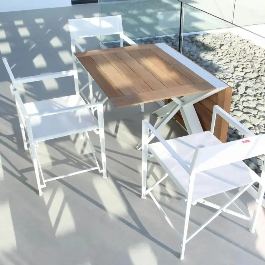 Distinguished Royal Botania Traverse table with warm light brown teak wood and sleek white-coated aluminum crossing supports