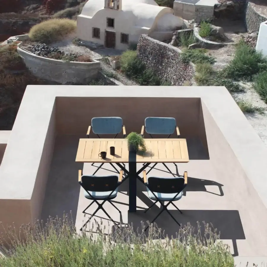 Distinguished Royal Botania Traverse table with light brown teak wood and a dark coated aluminum base built with an X-shaped support