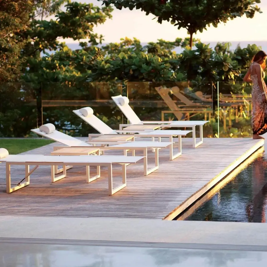 Elegant Royal Botania Ninix lounger with a matte white coated steel frame and Batyline seat, including a cylindrical headrest cushion