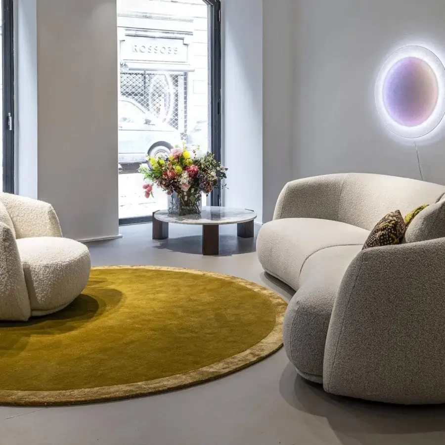 Lavish Moroso Pacific lounge chair with enveloping rounded form upholstered in textured off-white fabric and black polypropylene glides
