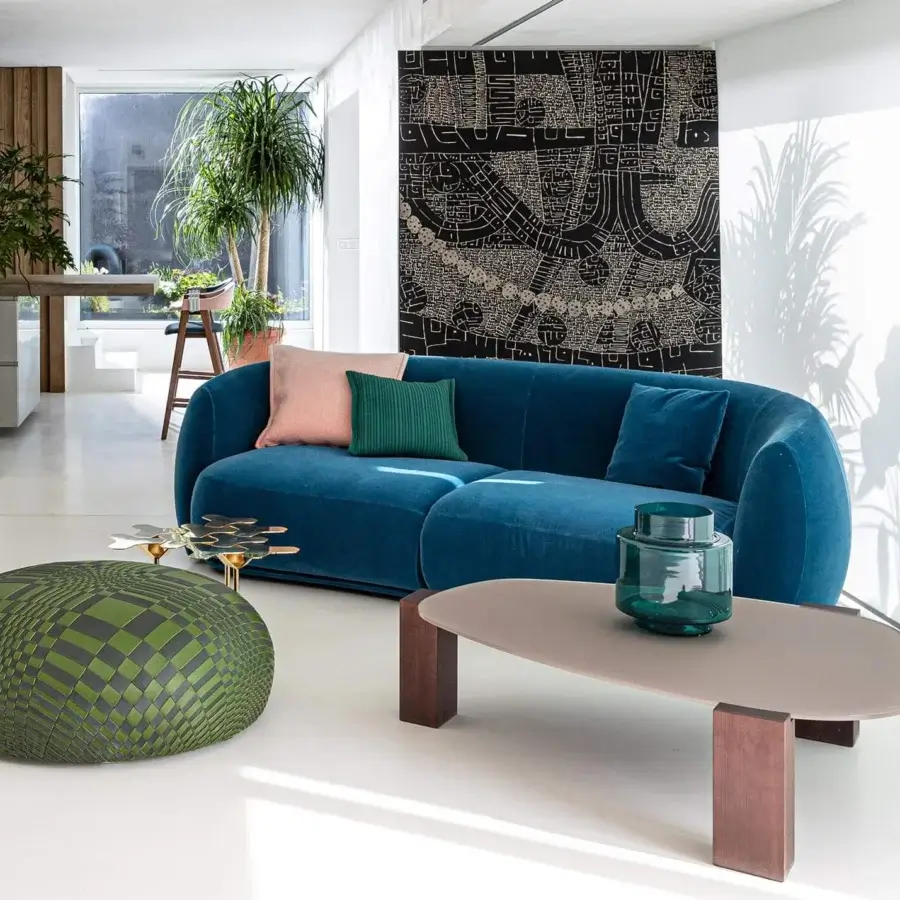 Distinguished Moroso Pacific sofa with curved form upholstered in rich blue textile and accented with pink and green pillows
