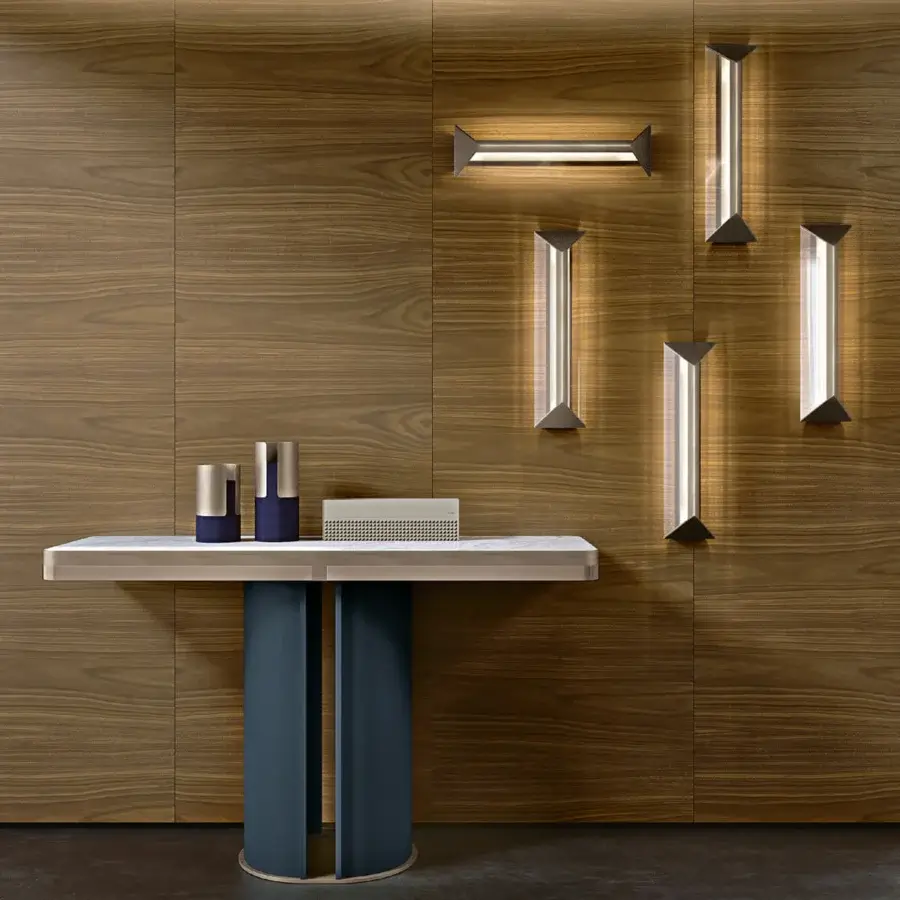 Elegant Turri Zero wall lamp with a triangular metal structure and clear glass casting amazing reflections