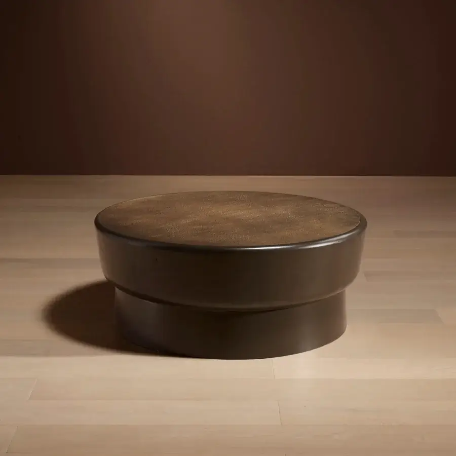 Bellavista Darius coffee table, dark brown matte finish, two-tiered rounded design with textured tabletop and cylindrical base on wood flooring.