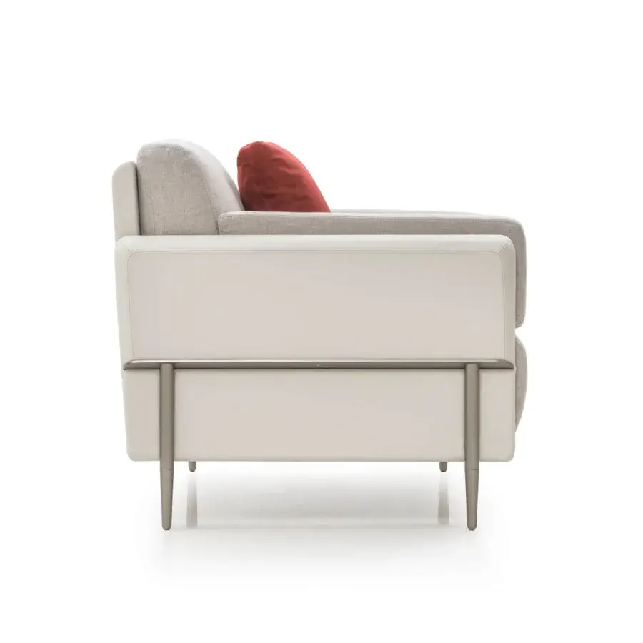 Elegant Turri Zero lounge chair with light fabric cushions, a red accent and platinum satin-finished metal structure