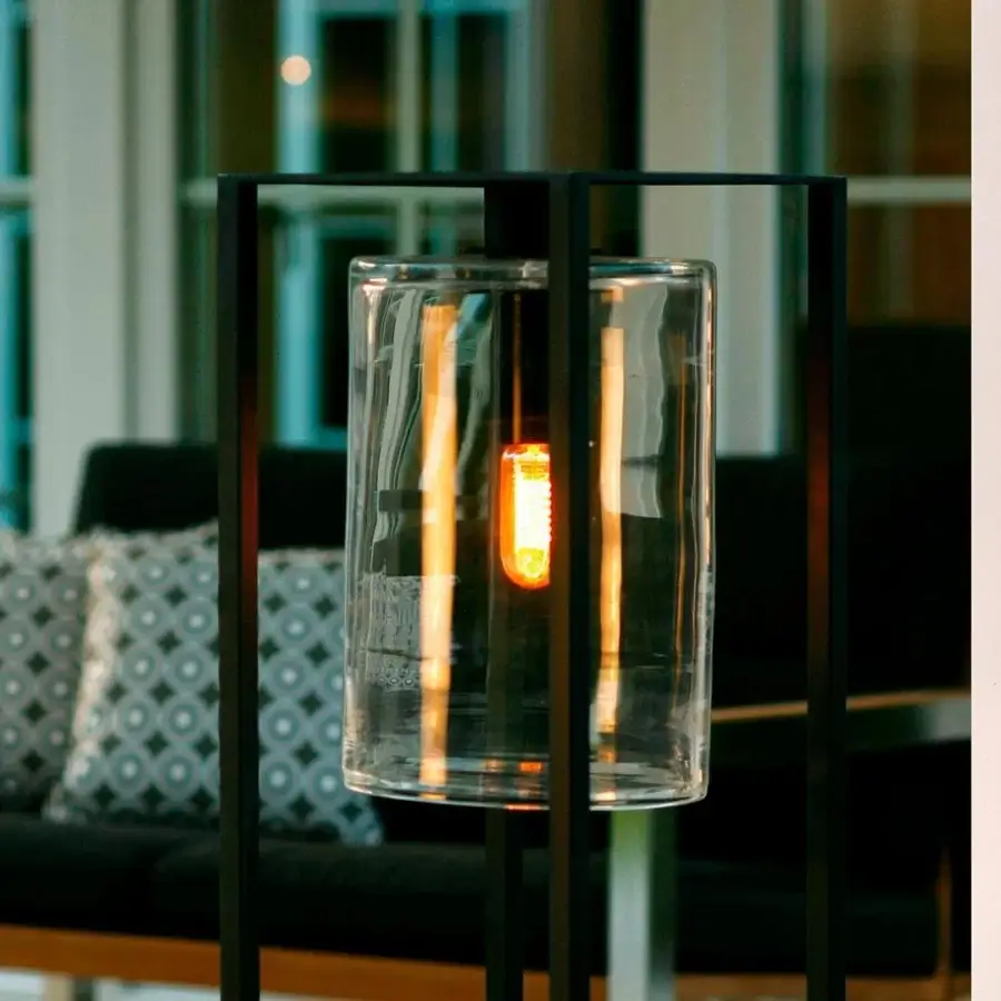 Exceptional Royal Botania Dome Move floor lamp with a black powder-coated aluminum frame and clear handmade glass cylinder emitting a warm glow