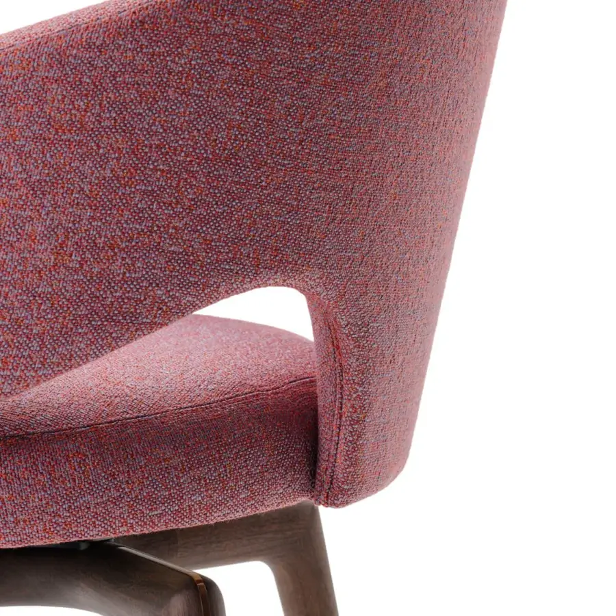 Lavish Turri Blues armchair presents a sculptural silhouette upholstered in textured reddish-pink textile with smooth wooden legs