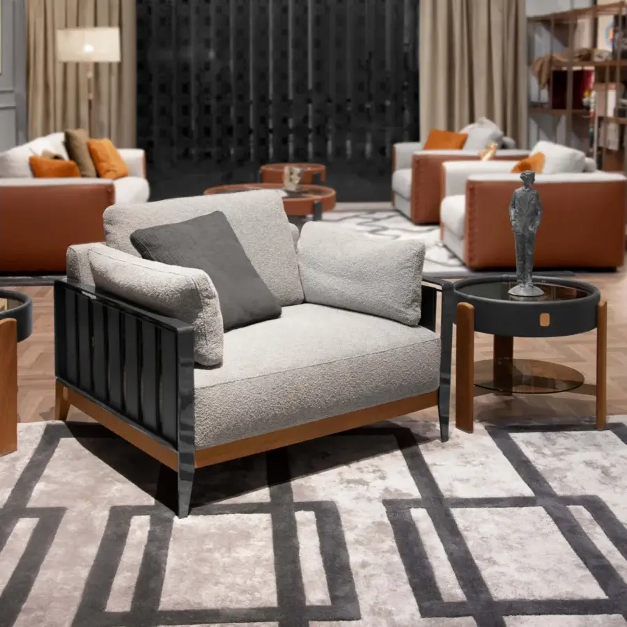 Distinctive Formitalia Daniela lounge chair with light gray textured fabric, wood base and dark-toned leather armrest straps