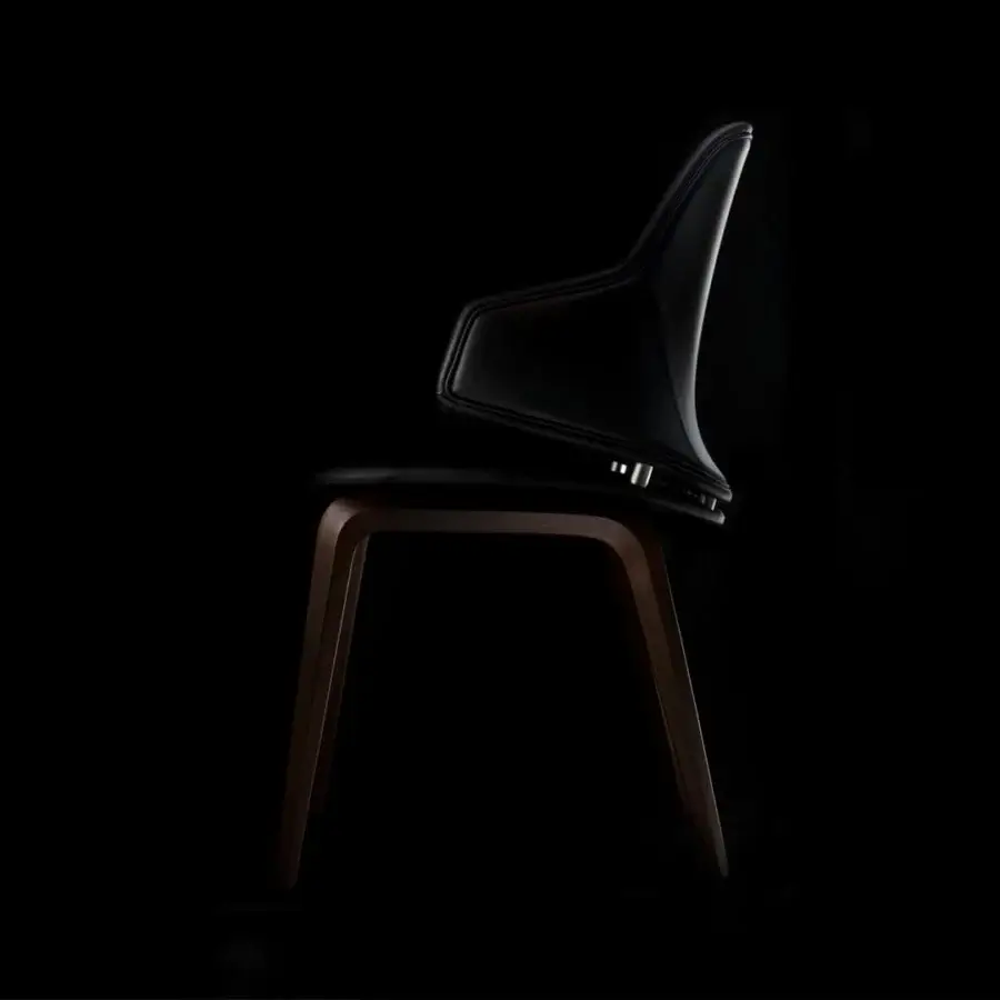 Lavish Reflex Vela chair in black leather with quilted detailing and Canaletto walnut crafted frame