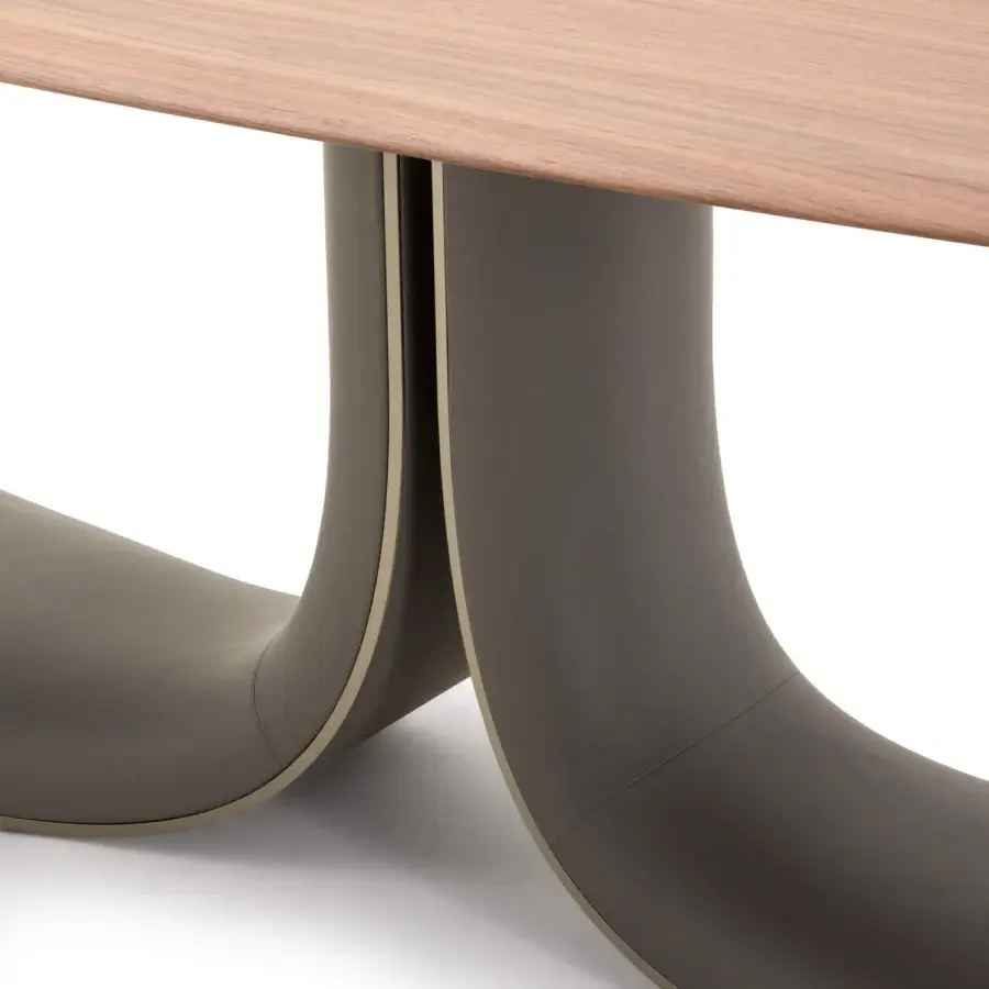 Distinguished Turri Soul table exhibits a serpentine base clad in dark taupe leather with a smooth, light-toned wooden top