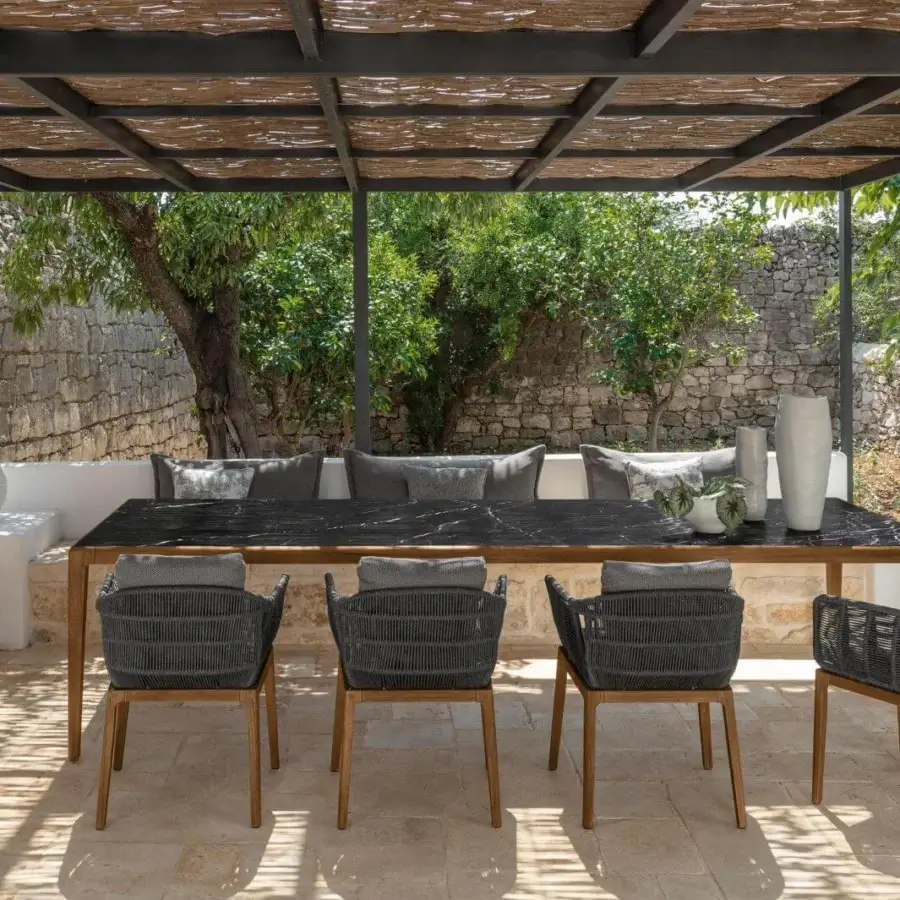 Elegant Talenti Cruise armchair with teak wood frame and gray woven synthetic seat built with coordinating cushions