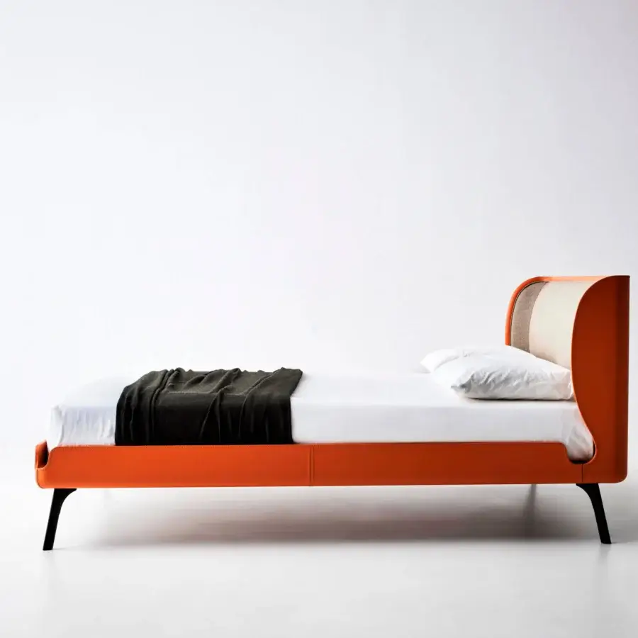 Sophisticated Bolzan Letti Gabri bed with enveloping headboard and angled black legs in cream textile with orange leather trim