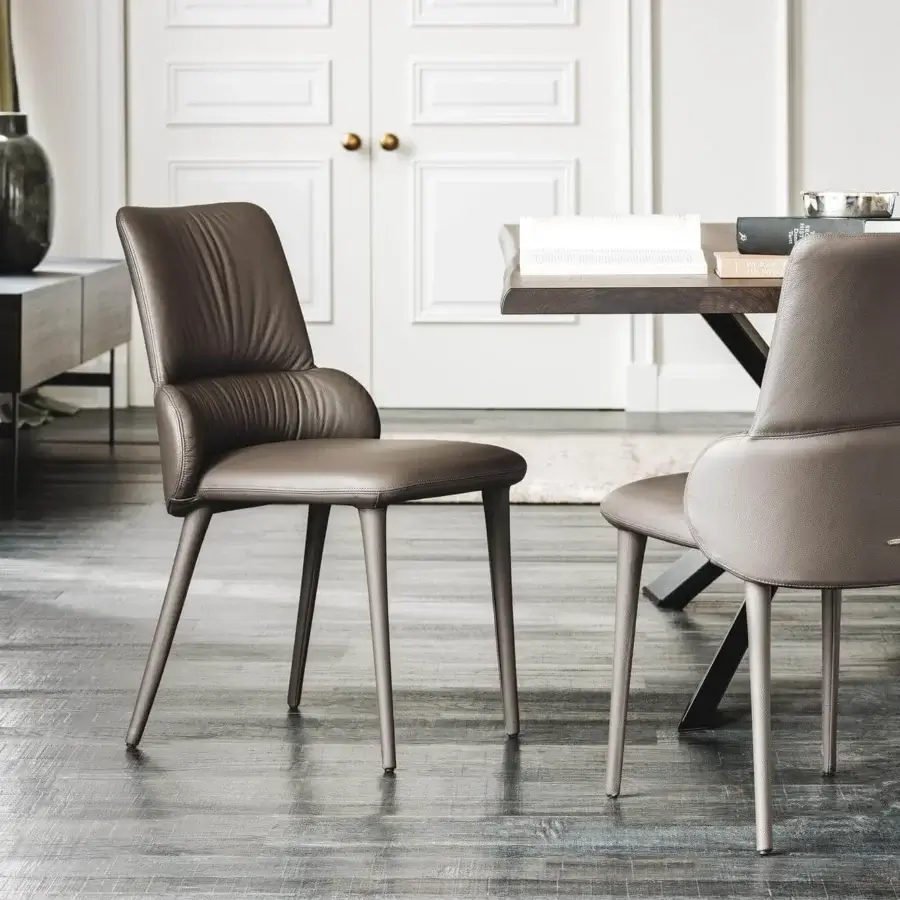 Distinguished Cattelan Italia Ginger chair upholstered in soft brown leather with slender steel legs and curved silhouette