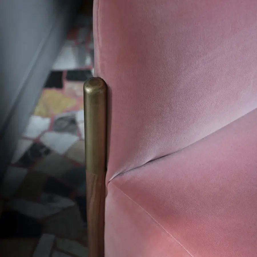 Lavish Bolzan Letti Flag lounge chair upholstered in smooth light pink textile with brown wood and brassy gold metal accents