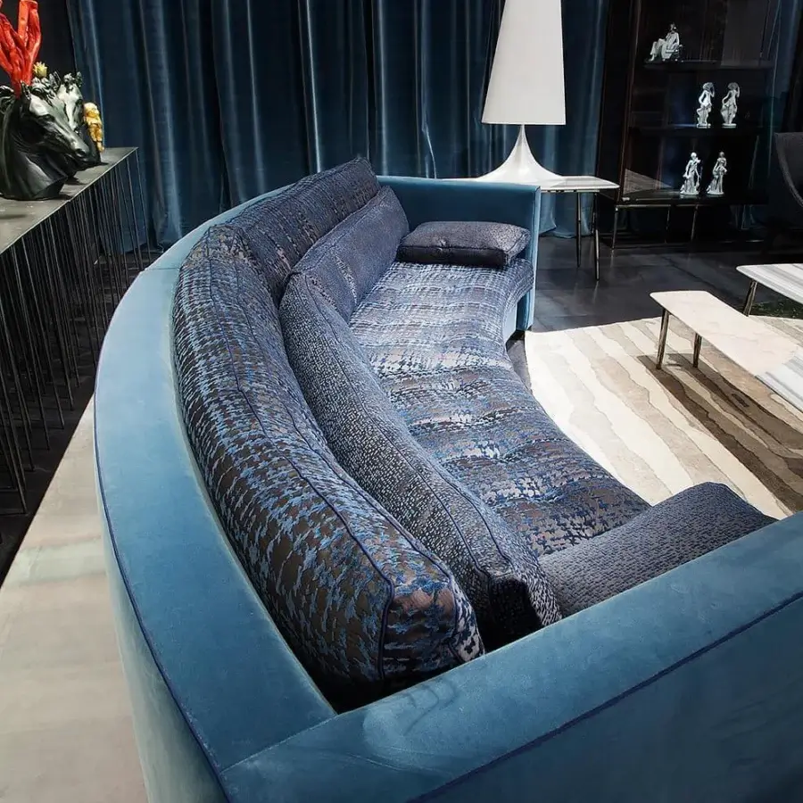 Distinguished Erba Alchimia sectional with curved form upholstered in medium blue textile and darker patterned blue cushions crafted in Italy