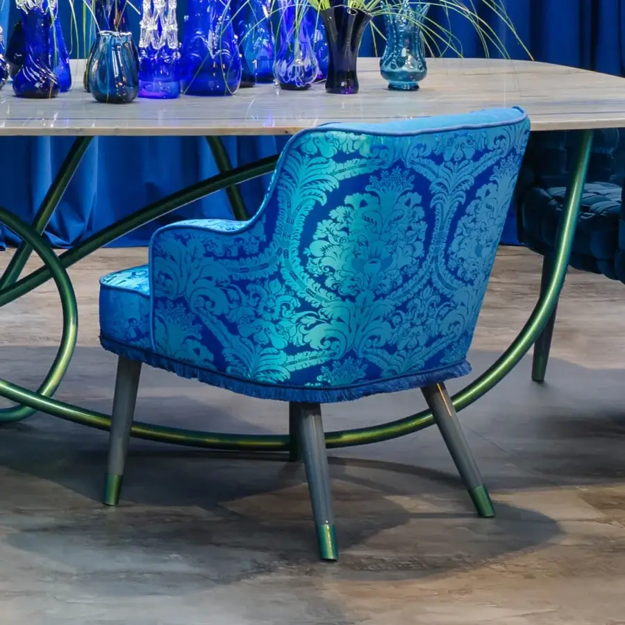 Lavish Turri Azul armchair with vibrant blue patterned textile, stylish fringe and glossy lacquered polyester wooden legs with golden accents