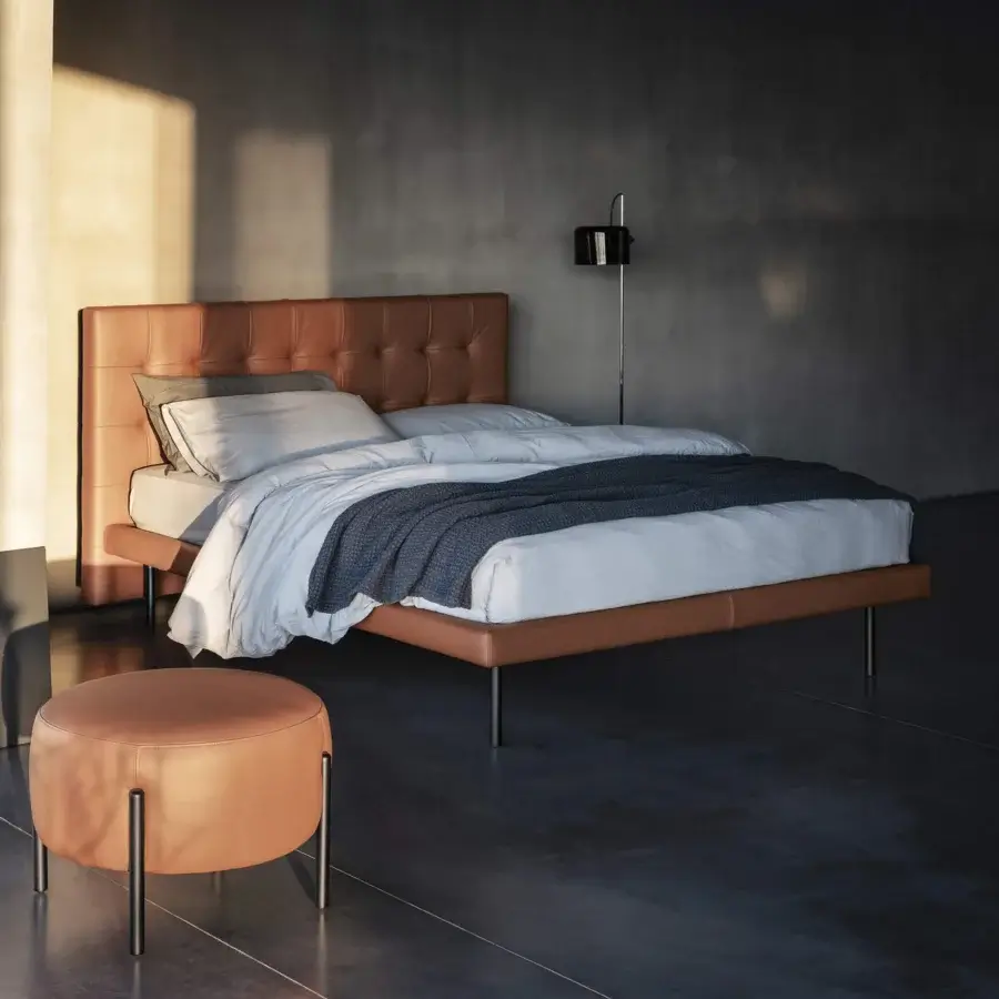 Superior Bolzan Letti Freedom bed with tan leather-like upholstery and a meticulous capitonné headboard built with dark metal legs