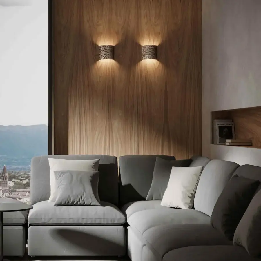 Sophisticated Stillux Random wall lamp with curved hammered metal in a dark neutral tone projecting ambient light