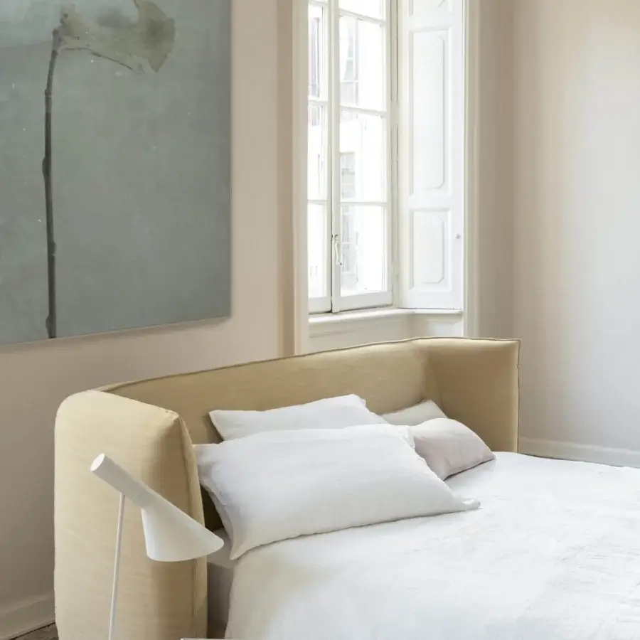 Sophisticated Bolzan Letti Jill bed with a gently curving headboard upholstered in light tan textile and Italian firwood structure