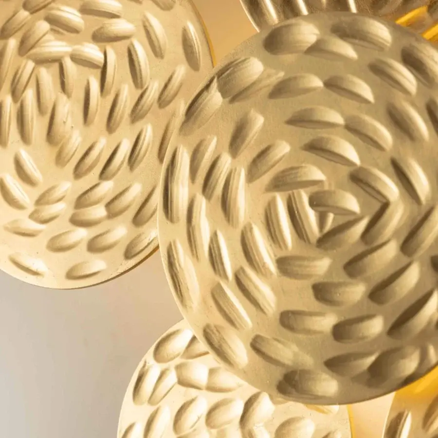 Exclusive Stillux Random wall lamp crafted in overlapping hammered metal discs with gold tone finish emitting warm light