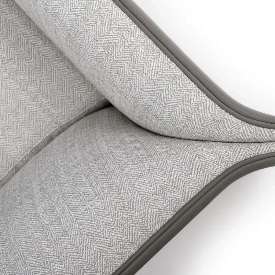 Distinguished Turri Blossom lounge chair with curved lines and metal-embellished corners upholstered in light gray herringbone textile with matte finish