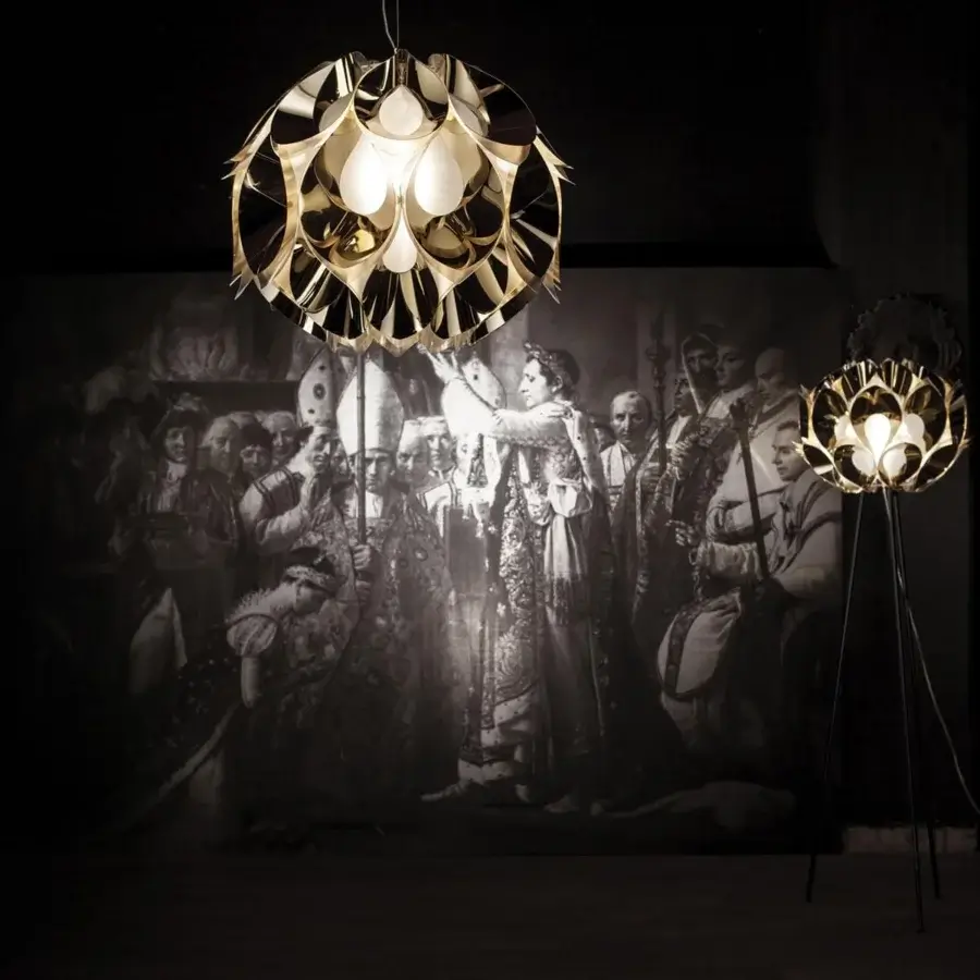 Innovative Slamp Flora floor lamp with reflective gold petal-like structures and dark metal legs emitting warm diffused light