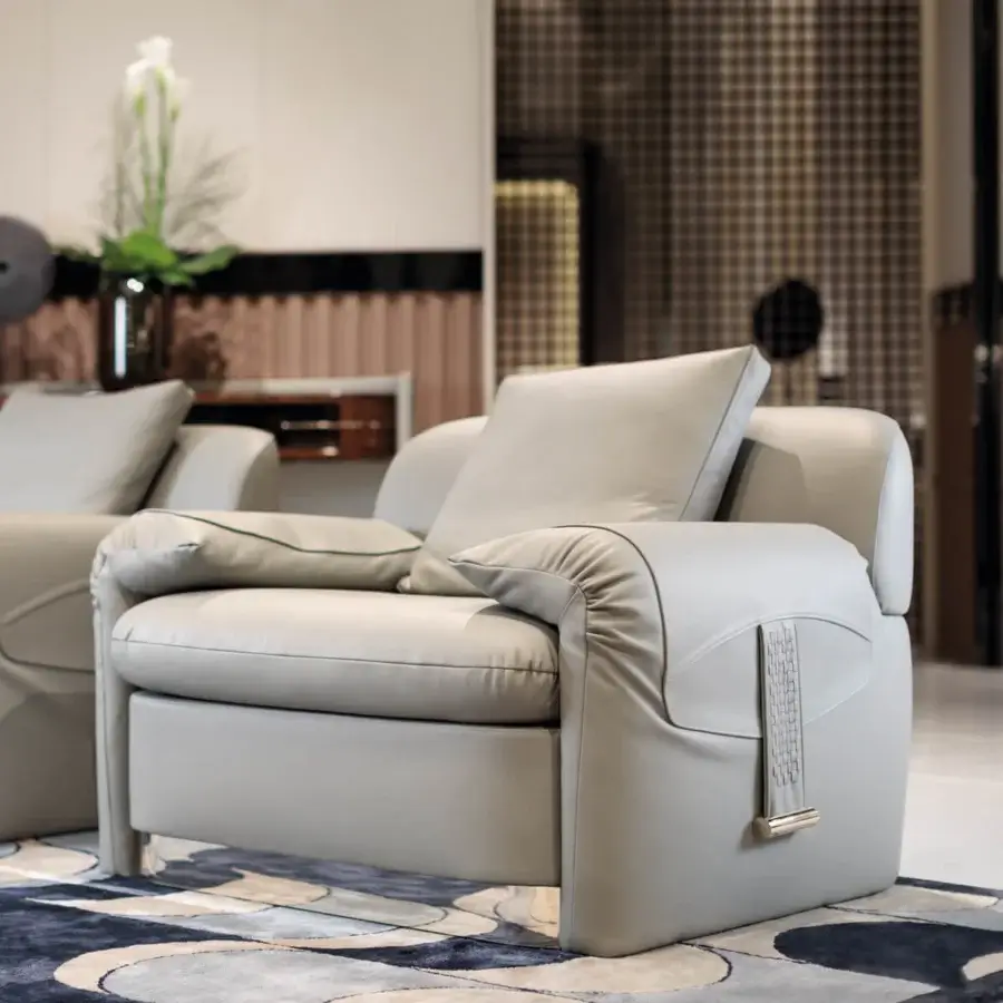 Distinctive Turri Eclipse lounge chair with light gray leather cushioning and light gold metal accents