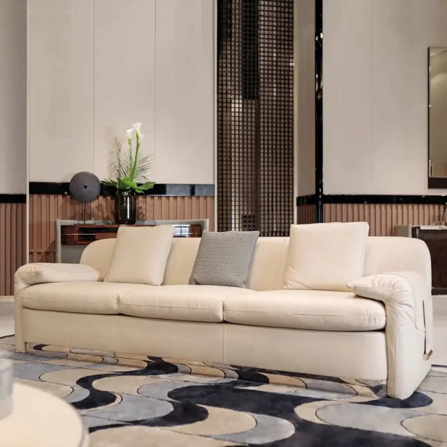 Distinctive Turri Eclipse sofa with sinuous lines, folded armrests and light cream-colored upholstery with gold metal details