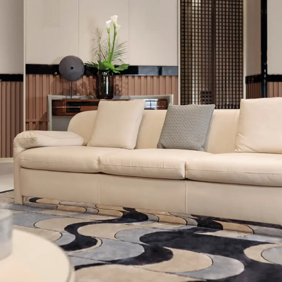 Superior Turri Eclipse sofa with sinuous lines, slightly folded armrests and smooth light beige textile upholstery with light gold metal details