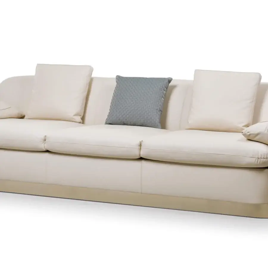 Elegant Turri Eclipse sofa with sinuous lines, inward folding armrests and creamy off-white textile upholstery with light gold metal details