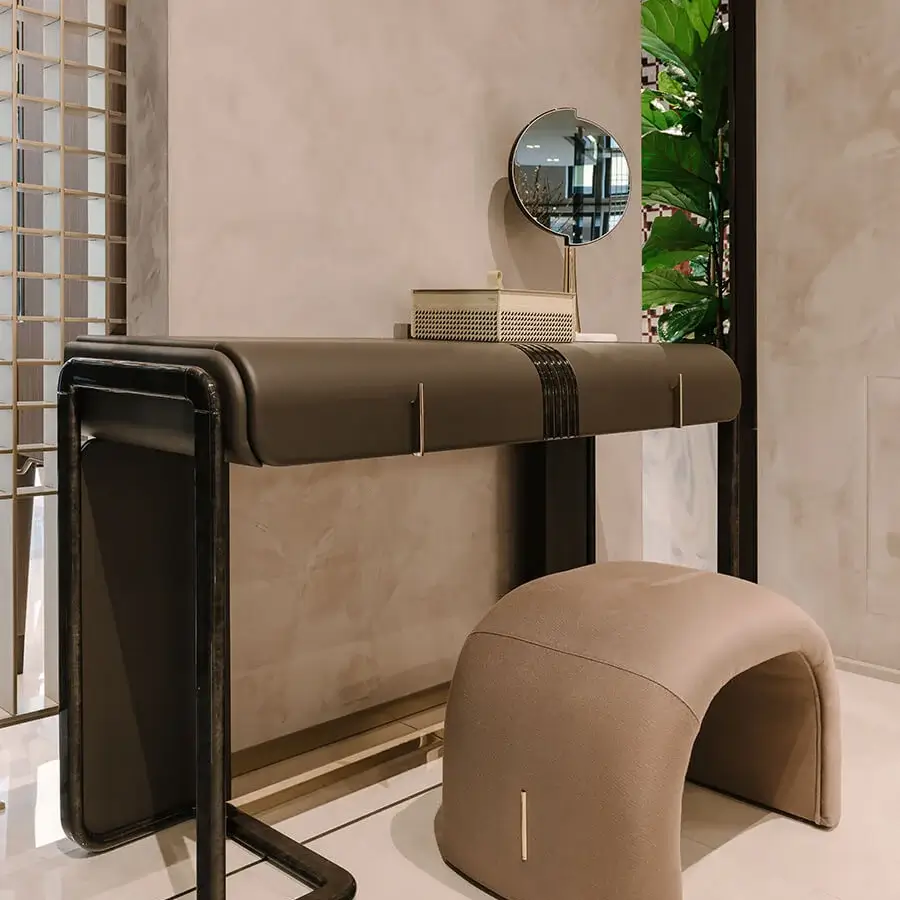 Elegant Turri Eclipse ottoman with warm beige textile upholstery and gold metal detail in a matte finish