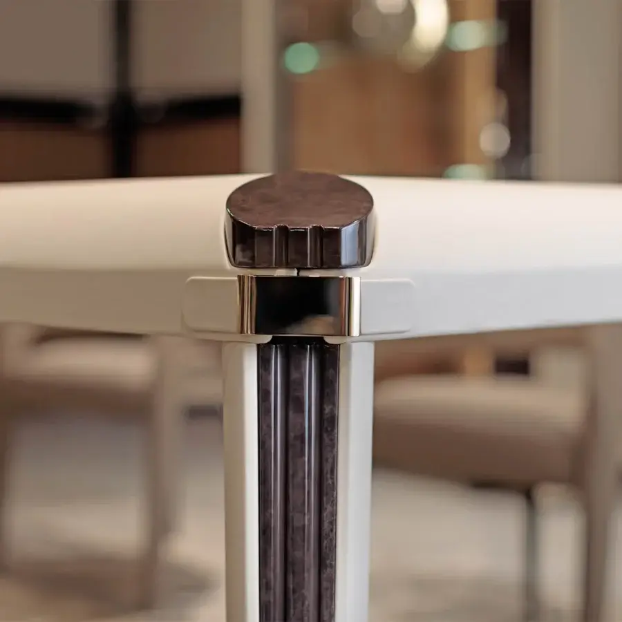 Superior Turri Eclipse table with light-colored top, grooved wooden legs and refined leather inserts, accented with gold metal details