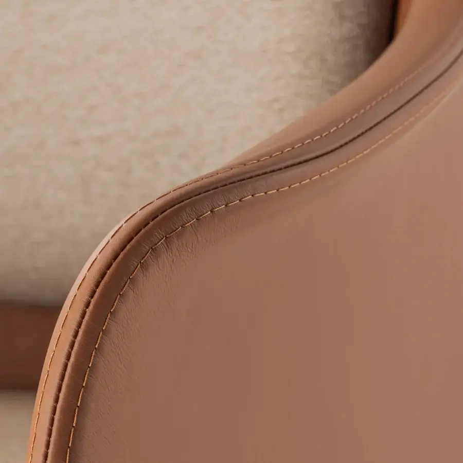 Elegant Turri Echo armchair with inviting light brown leather seating and meticulous stitching along curved armrests