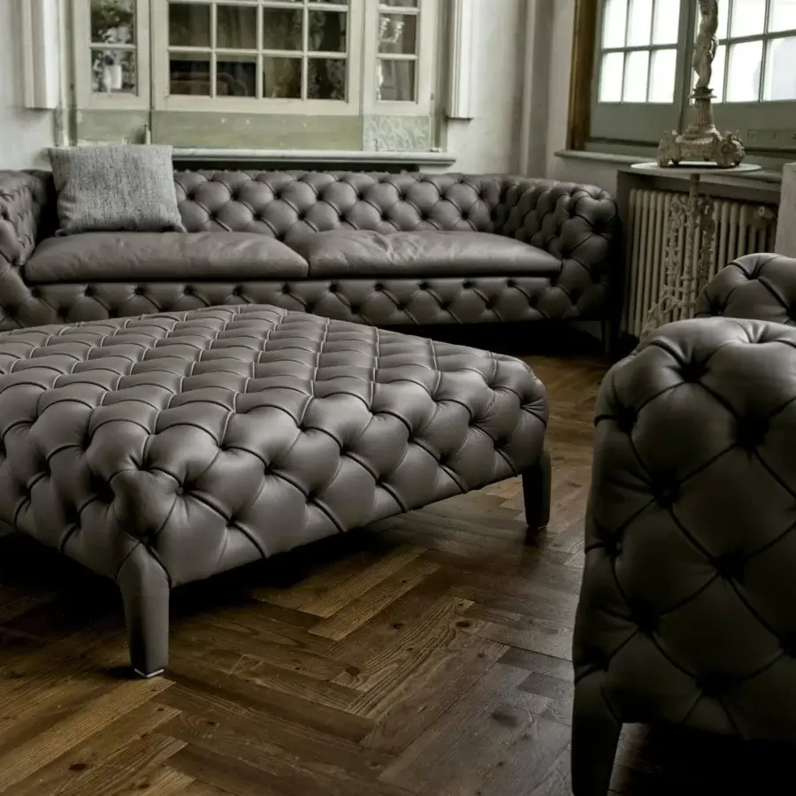 Elegant Arketipo Windsor lounge chair crafted in dark gray leather-like textile with distinctive button-tufted upholstery and curved silhouette