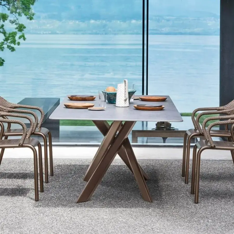 Refined Varaschin System Star table with light gray HPL tabletop and angular extruded aluminum base in medium brown hue