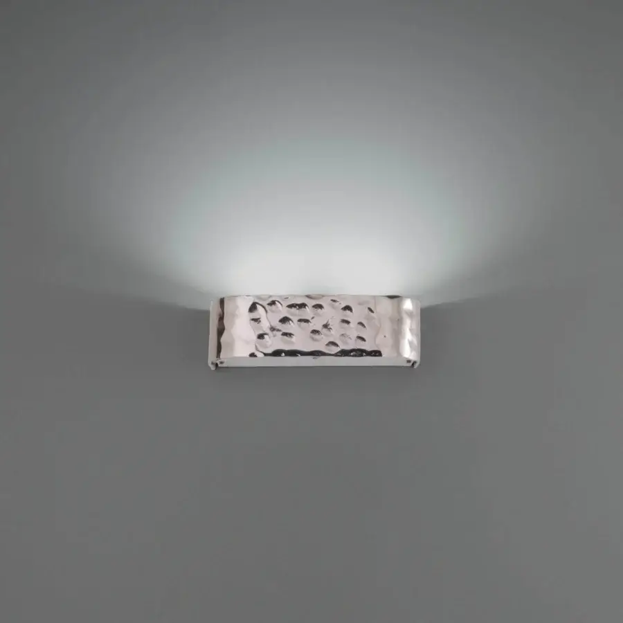Elegant Stillux Shape wall lamp crafted in Italy with a reflective hammered metal frame and upward glow