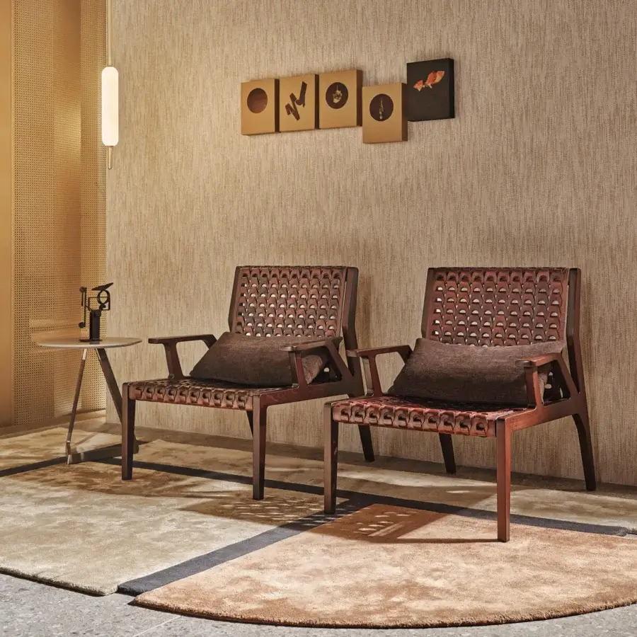 Elegant Turri Net Lounge Chair with woven saddle leather and warm-toned walnut wood structure complemented by a brown textile cushion