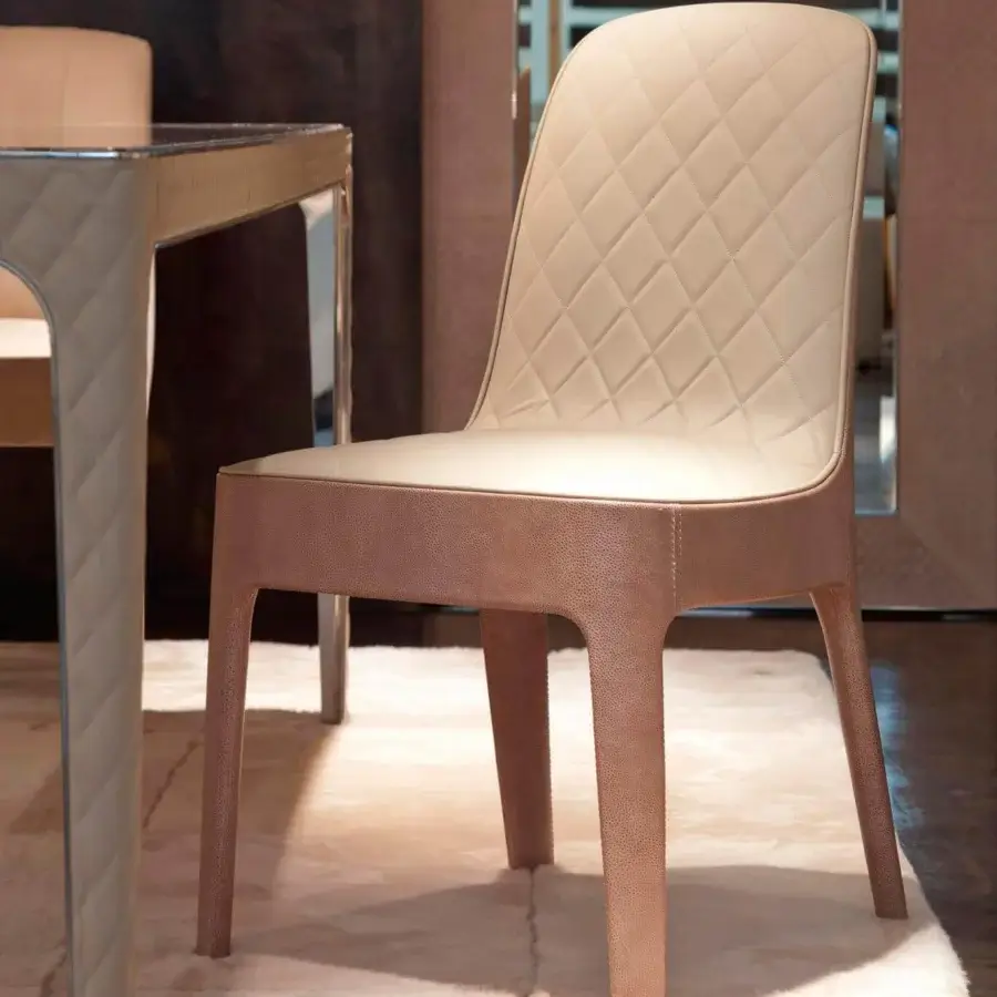 Distinctive Rugiano Aria chair with light beige textile and diamond-patterned stitching, built with polished lacquer legs