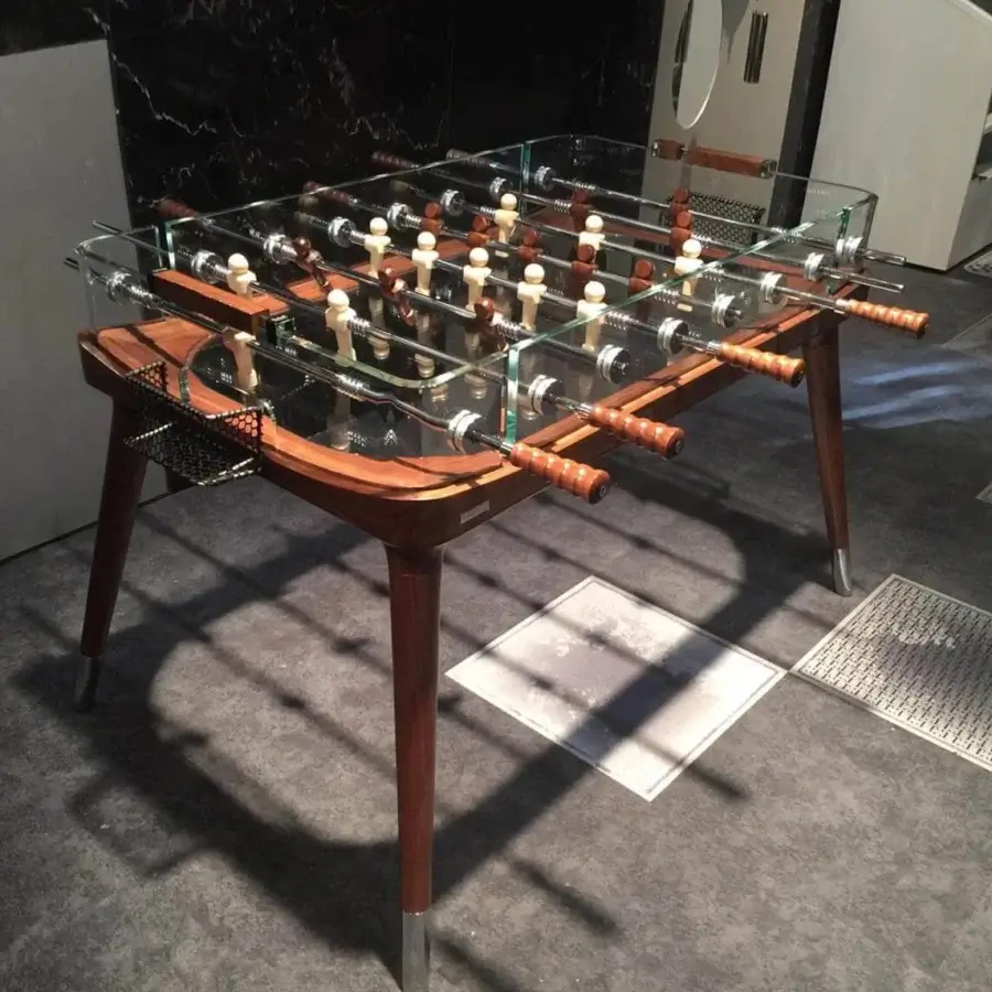 Elegant Teckell 90º Minuto foosball table with a solid molded wood structure and crystal perimeter, built with glossy medium brown legs and metallic mesh goals