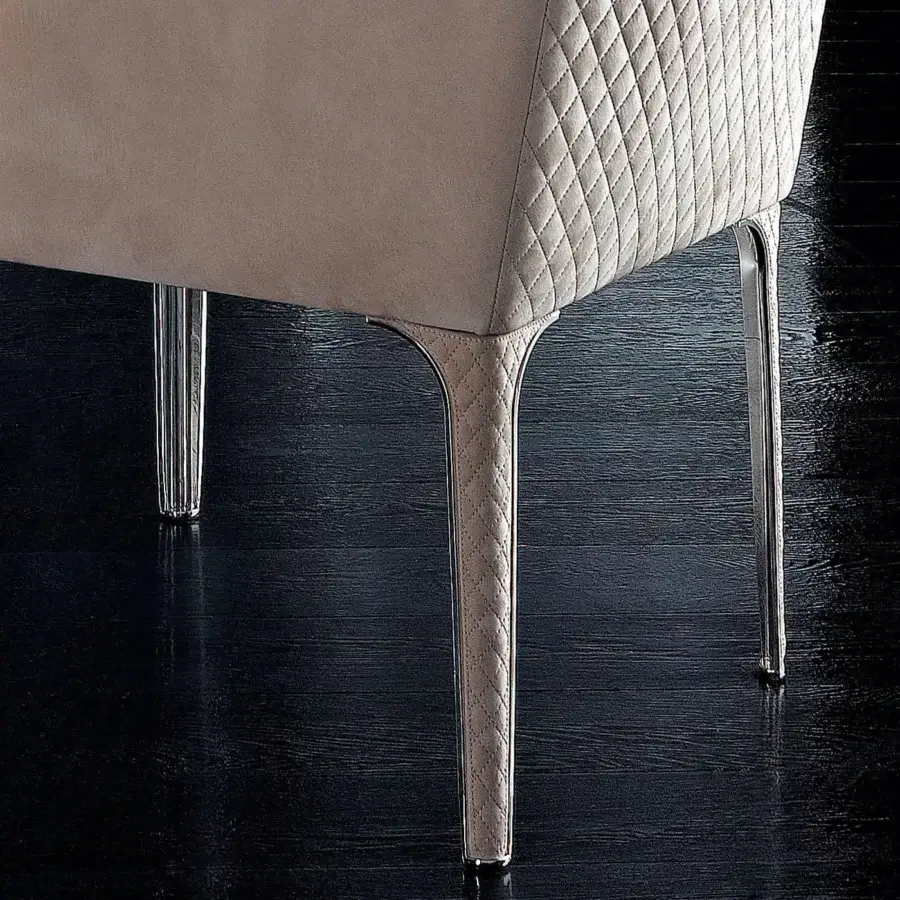 Elegant Rugiano Arianna armchair upholstered in light beige textile with quilted design and steel legs crafted in leather