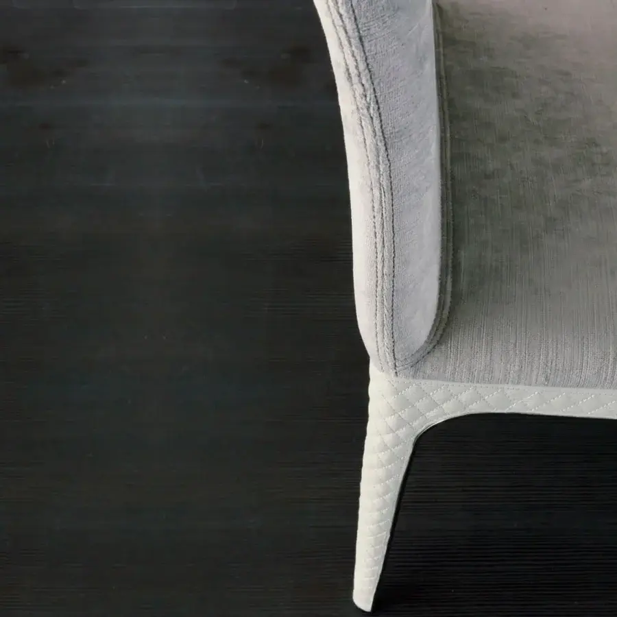 Superior Rugiano Viviane chair with curved back and high-end metal legs upholstered in light gray textile with white quilted material