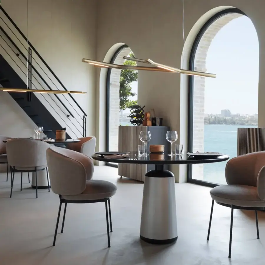 Distinguished Horm Concorde armchair with a fluid form, neutral gray textile upholstery and slender raw metal legs