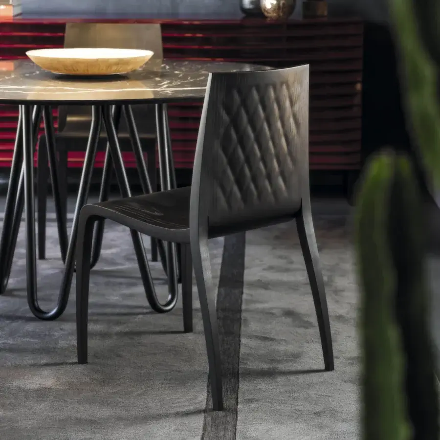 Superior Horm Ki chair crafted in Italy with solid wood legs, plywood seat and backrest, exhibiting quilted detailing and a dark tone