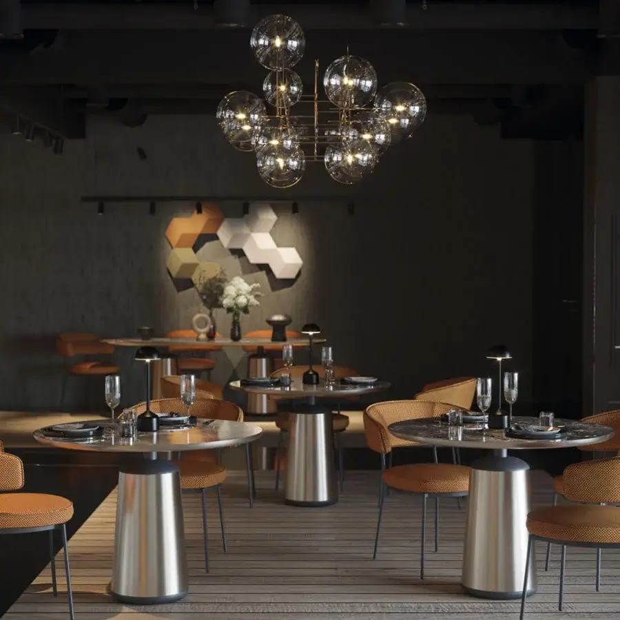 Superior Horm Marien table with a round dark-toned Fenix tabletop and cylindrical metal base exhibiting a brushed reflective finish