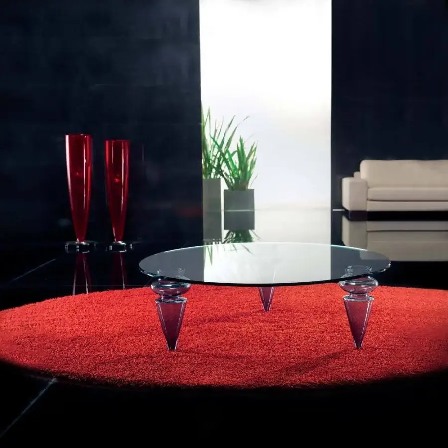 Transparent conical supports hold a circular glass top above a reddish-orange textured disc on a dark reflective surface