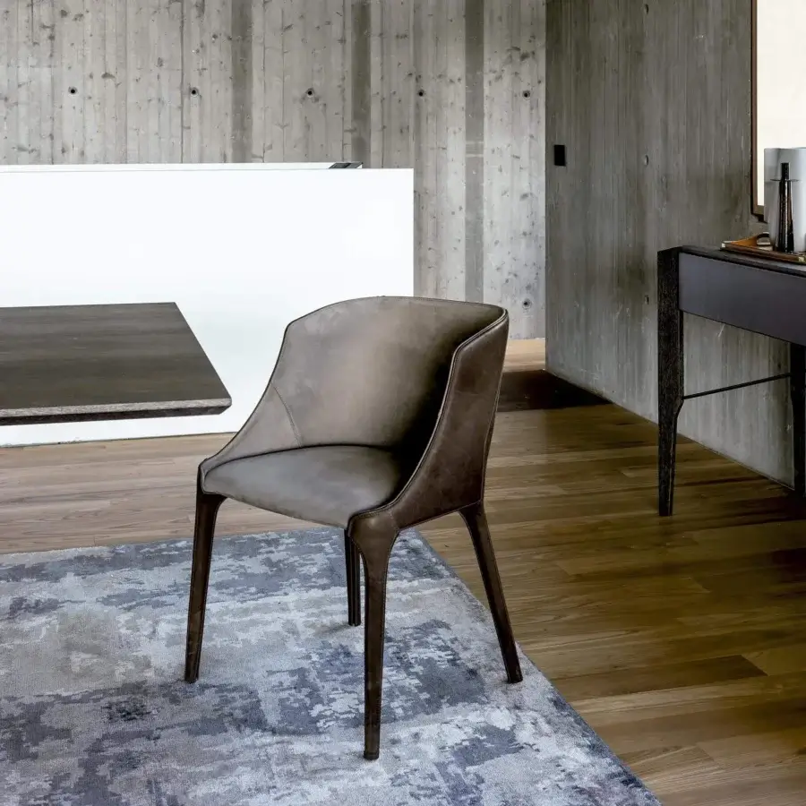 Elegant Arketipo Goldie chair upholstered in muted gray textile with brown undertones and matte finish with dark brown leather trim and wood legs