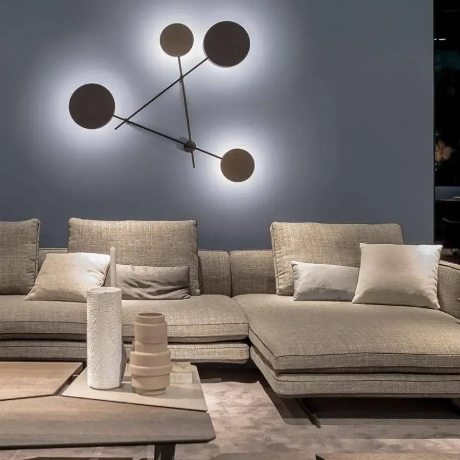 Distinguished Arketipo Iride wall lamp with angular bronze-toned form and micaceous brown metal rods emitting a soft LED glow
