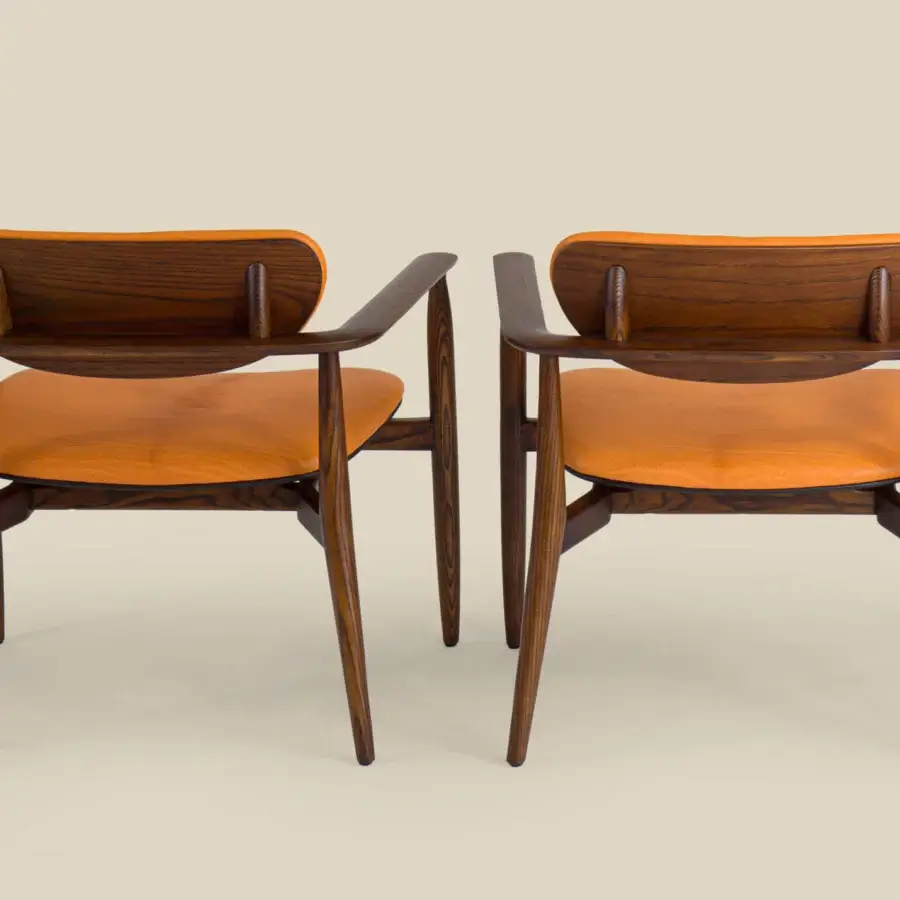 Superior Borzalino Regina lounge chair with vibrant orange synthetic upholstery and dark-toned wood grain structure